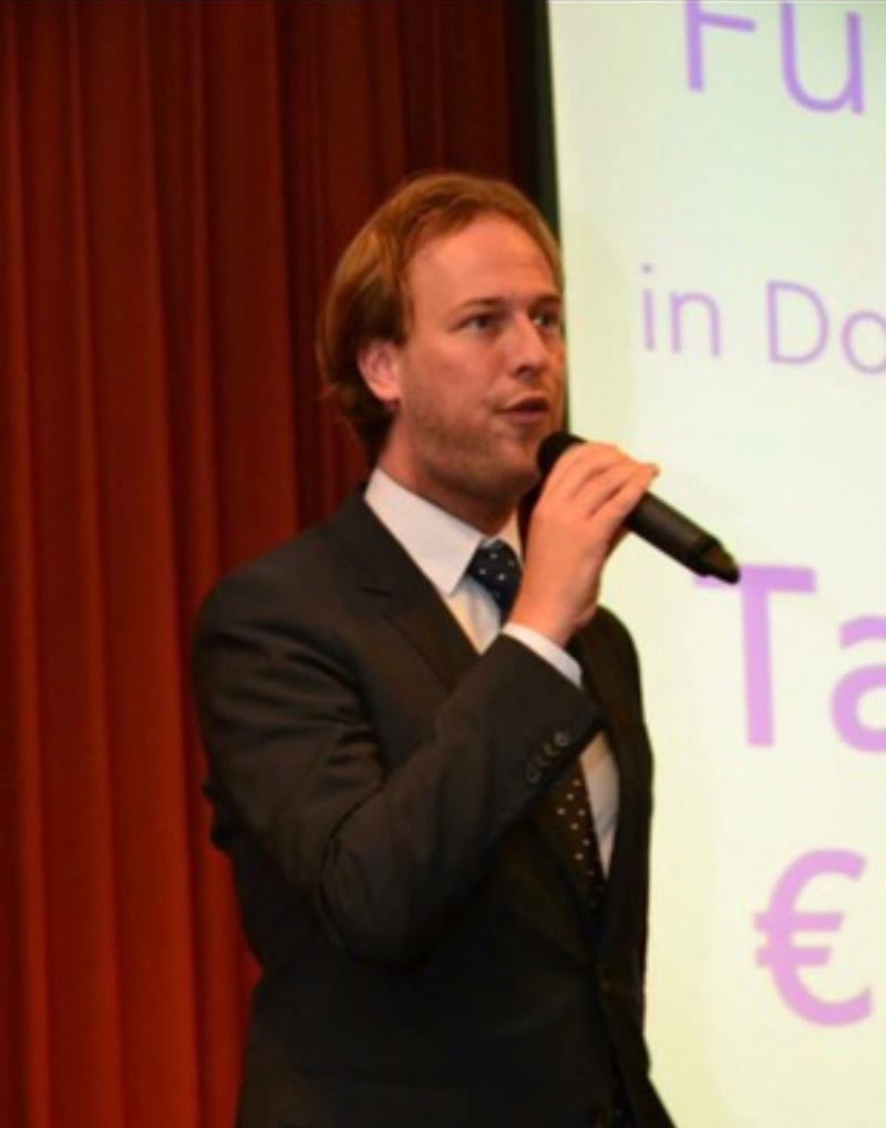 Dennis met de microfoon voor een zaal